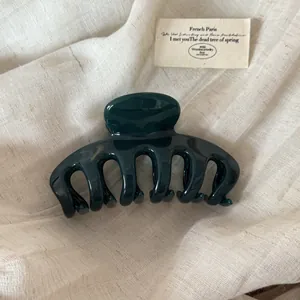 Detailed view of large forest green glossy hair claw clip for elegant styling