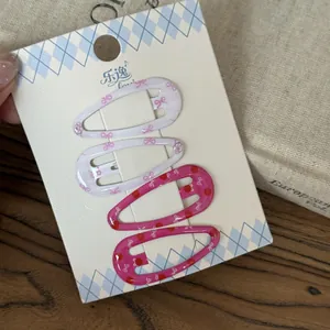 Vista detallada de cuatro coloridas pinzas BB con adorables estampados de lazos y lunares