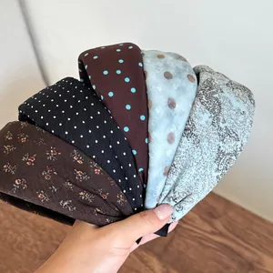 Close-up of variety of retro floral and polka dot wide headbands with fabric texture