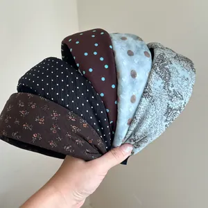 Close-up detail of five vintage wide headbands featuring polka dot and floral patterns
