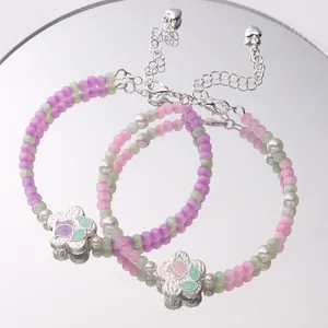 Detail of beaded flower bracelet with matte silver tulip charm and colorful oil drip beads.