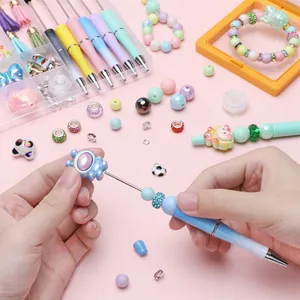 Primer plano de una mano montando un bolígrafo de cuentas DIY con cuentas de colores