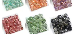 Vue détaillée de perles en verre transparent de 8mm avec motifs à l'encre de Chine colorée.
