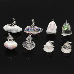 Detail view of various Halloween-themed resin pendants with ghost, cloud, and moon shapes