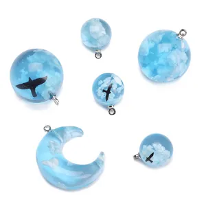 Blue resin sky pendants with white clouds and black bird motifs for jewelry making