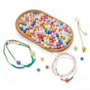Close-up of colorful AB acrylic bubble beads and handmade DIY bracelets on white background.