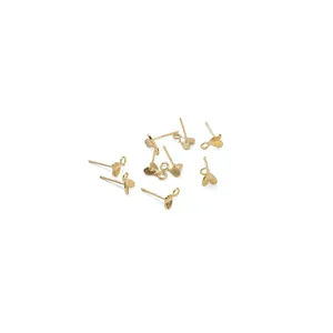 Close-up of golden heart-shaped alloy ear studs with hanging loops for DIY jewelry