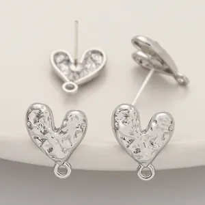 Macro view showing the textured detail of silver-colored heart stud earring components.
