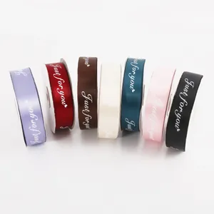 Close-up of 'Just for you' printed satin ribbons in multiple colors for gift wrapping