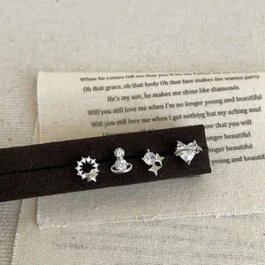 Detailopname van een zirkonia oorknopjesset met hart- en planeetmotieven op een display