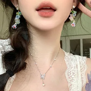 Close-up detail of colorful lily of the valley crystal tassel earrings worn by model