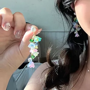 Close-up detail of colorful lily of the valley crystal tassel earrings with pearl