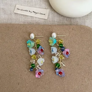 Detailed macro view of colorful lily of the valley crystal flower tassel earrings