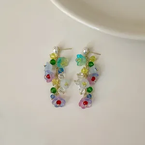 Macro view showing colorful crystal beads and floral patterns on these tassel earrings.