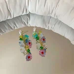 Detailed macro view of colorful crystal lily of the valley tassel earrings on a mirror