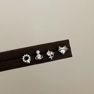 Detailopname van een zilveren zirkoon oorbellen set met hart, planeet en ster op vilt