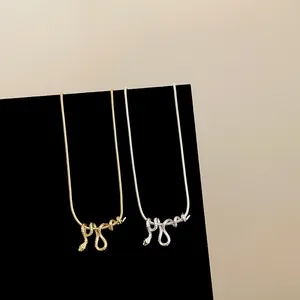 Gedetailleerd zicht op verstrengelde slangenkettingen in goud en zilver op zwart fluweel.