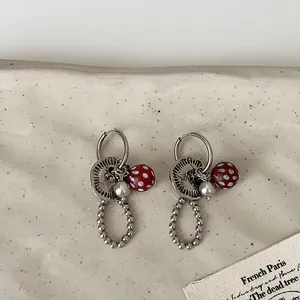 Gedetailleerde weergave van vintage oorbellen met knoopbedels en polkadot kralen