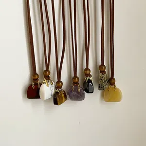 Detailweergave van tasvormige hangers van natuursteen in verschillende kleuren