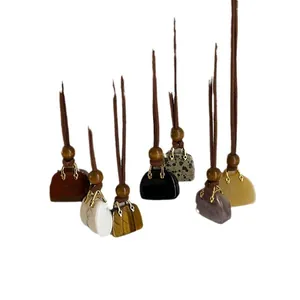 Ketting met natuurlijke tijgeroog hanger in de vorm van een tasje met koord.