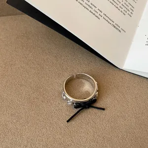 Primo piano dettagliato di un anello a pianeta argento regolabile con fiocco in corda