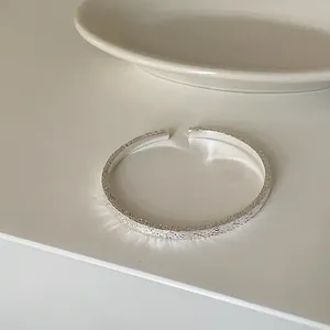 Detailansicht der eleganten Hammerschlag-Textur an diesem silbernen offenen Armreif.