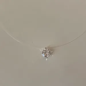 Close-up of minimalist invisible fishing line necklace with a sparkling solitaire pendant