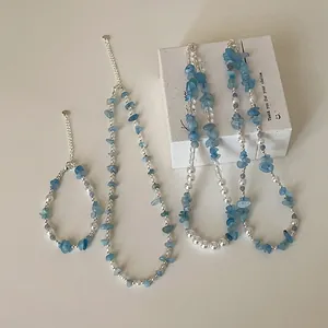 Detailopname van een set van aquamarijn natuursteen en parel kralen ketting.