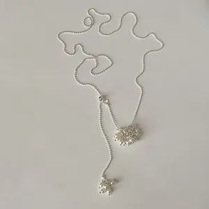Detailed macro view of a silver beaded long necklace featuring white pearl grape clusters