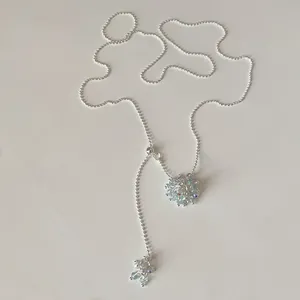 Detail view of adjustable silver pull chain necklace with iridescent crystal clusters.