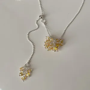 Detailed view of yellow crystal grape cluster on adjustable silver chain necklace.