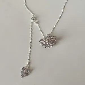 Detailed view of translucent crystal grape pendants on a silver-tone lariat necklace.