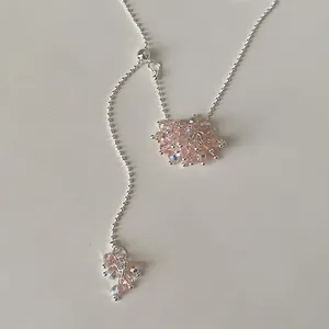 Detailed view of pink crystal grape cluster pendant on adjustable silver lariat necklace