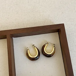 Detailed view of U-shaped brown resin hoop earrings with elegant gold-tone accents