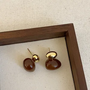 Elegant brown resin and gold metal ball drop earrings for women displayed in wooden tray