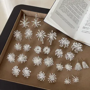 Collection of silver firework stud earrings on a brown velvet jewelry display tray