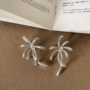 Close-up of silver metal firework earrings showing unique artistic design details.