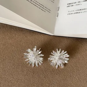 Detailed macro view of silver fireworks earrings featuring delicate pearls and crystals.
