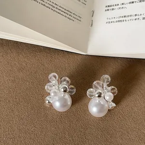Detailed close-up of elegant firework-inspired stud earrings with pearls and crystals.