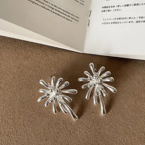 Close-up of elegant silver firework-shaped stud earrings with a polished metallic finish