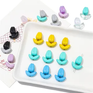 Perles tulipes colorées en acrylique pour la création de bijoux sur un plateau en céramique