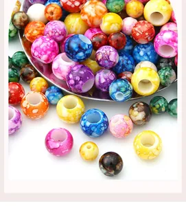 Detalle de cerca de cuentas acrílicas jaspeadas de colores con agujeros para crear joyas DIY