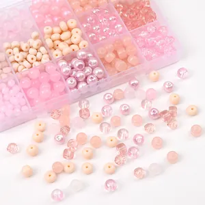 Detailed close-up view of various pink glass and crystal beads for DIY jewelry making projects.