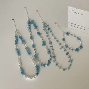 Detailweergave van aquamarijnsteen en parelkralen halskettingset met geschenkdoos.
