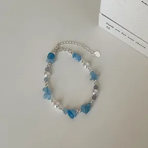 Detail van de kralenketting met natuurlijke aquamarijnsteen en parels op witte achtergrond