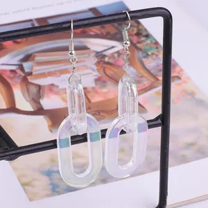 Close-up of iridescent transparent acrylic chain link earrings on a black stand