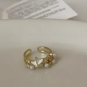 Detaillierte Nahaufnahme des eleganten Seesterns, der Perlen und Zirkonia auf diesem Goldring.