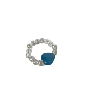 Elastic beaded ring with clear crystal beads and a charming blue heart stone pendant.