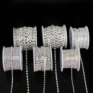 Close-up of various silver and AB iridescent rhinestone claw chains on white spools