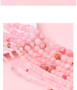 Vue détaillée de perles rondes en pierre synthétique rose de différentes tailles